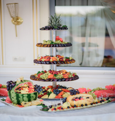 Tired dish with sliced plums, grape, ananas and other fruits sta
